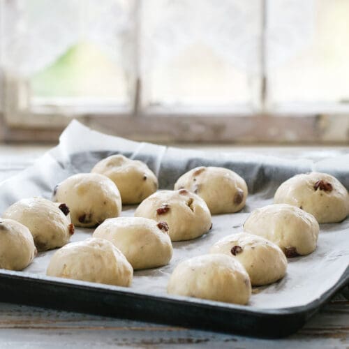 Top 10 Baking Tips for Success - Fresh dough balls with raisins resting on a tray lined with non-stick silicone baking paper.