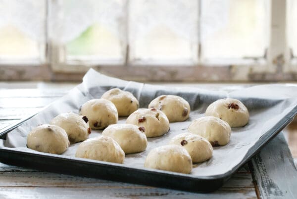 Top 10 Baking Tips for Success - Fresh dough balls with raisins resting on a tray lined with non-stick silicone baking paper.